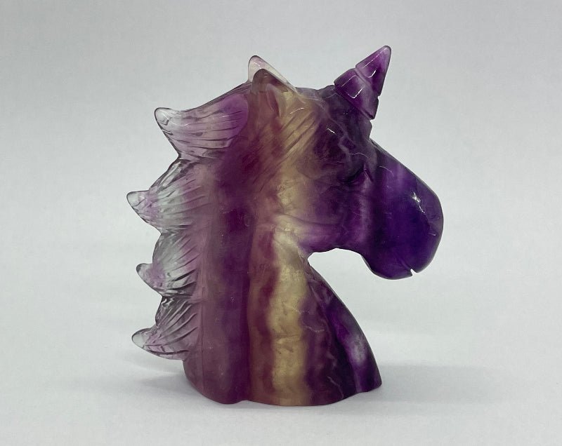 Detailliert geschnitztes Einhorn aus Regenbogen-Fluorit mit leuchtenden Farbverläufen.